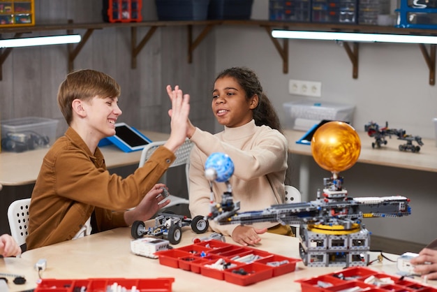 Foto niños que proyectan robots en la lección de ciencias