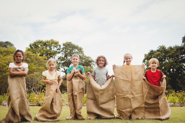 Niños que tienen una carrera de sacos