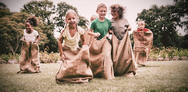 Niños que tienen carrera de sacos.