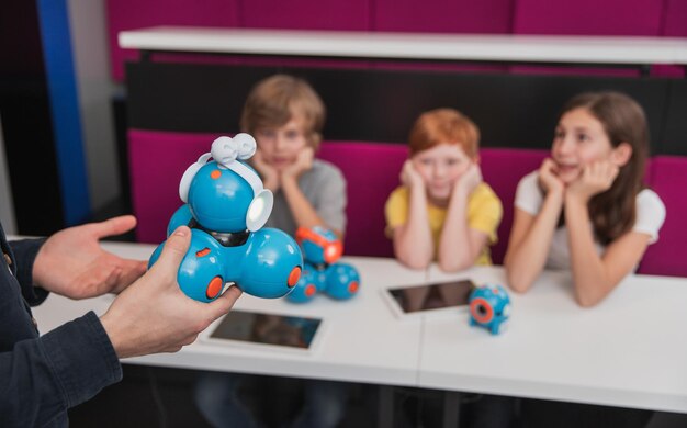 Niños que tienen lección de robótica en la escuela.