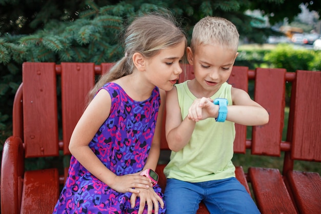 Los niños que usan relojes inteligentes con interés cuidan y los padres controlan la nueva tecnología para los niños