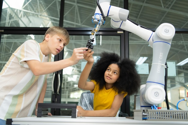 Los niños que usan la tecnología del robot de mano Los estudiantes están estudiando tecnología que es una de las STEM