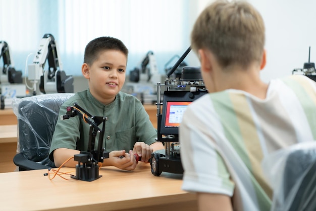Los niños que usan la tecnología del robot de mano Los estudiantes están estudiando tecnología que es una de las STEM