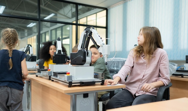 Niños que usan la tecnología de robots manuales y se divierten Aprendiendo la placa de circuito electrónico