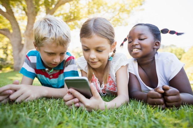 Niños que usan teléfonos inteligentes durante un día soleado