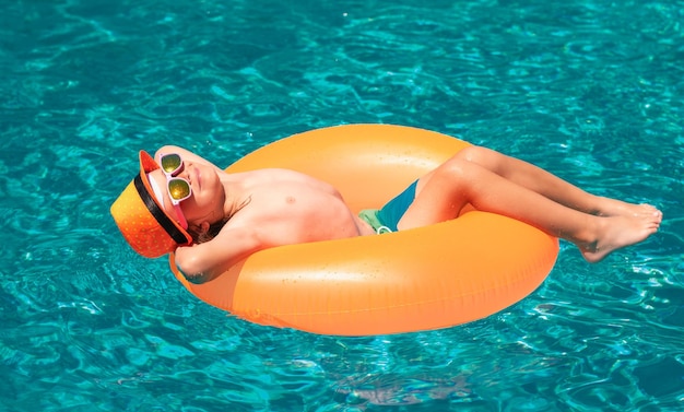 Los niños que viajan en verano nadan con un anillo flotante en las vacaciones de verano