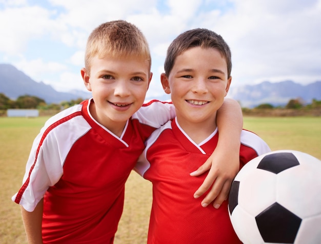 Niños retrato y equipo de fútbol en el campo feliz y colaboración o apoyar a la gente niños y listos para el partido y asociación o trabajo en equipo sonriendo y solidaridad o energía para el juego o amigos