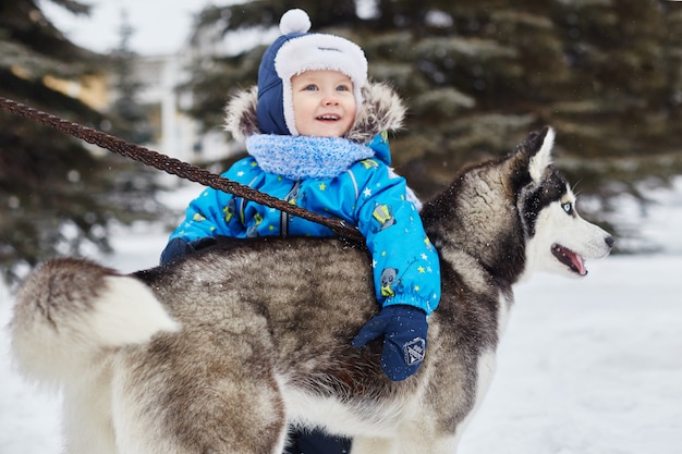 Los niños salen a jugar con el perro husky en invierno.