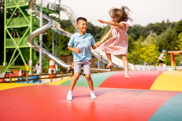 Niños saltando en un trampolín inflable en el parque de diversiones