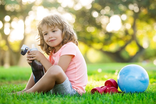 Niños sanos Estilo de vida deportivo Niño bebiendo agua Concepto deportivo Niño Ejercicios de salud y energía al aire libre