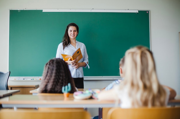 Niños sentados en el aula con el maestro