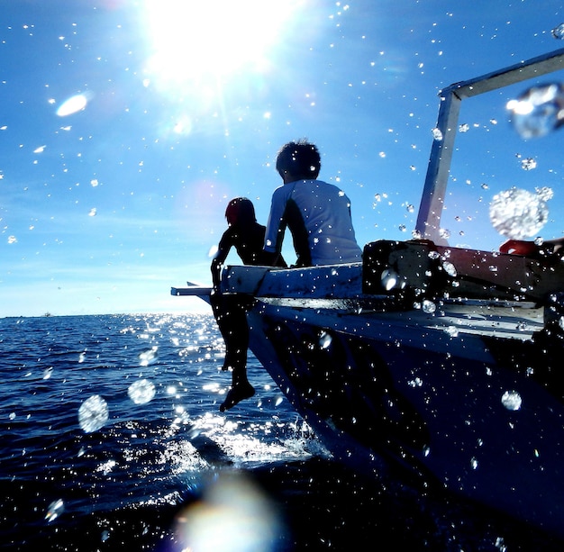 Foto niños sentados en un barco en el mar durante un día soleado