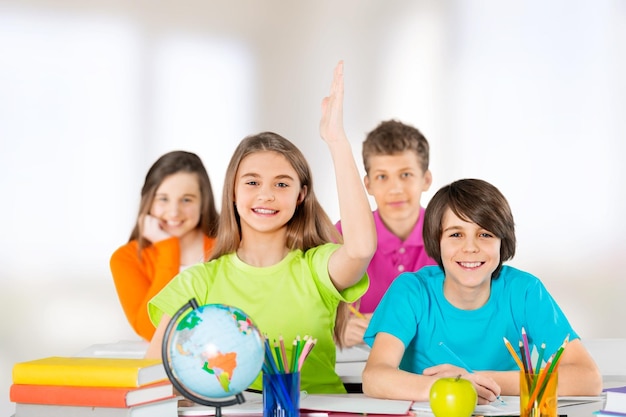 Niños sentados junto a la mesa durante la lección