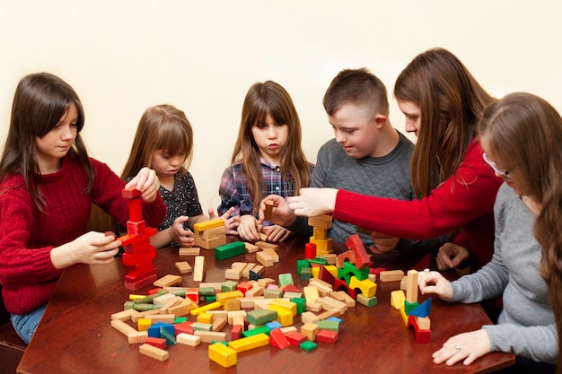 Niños con síndrome de down jugando con mujer y juguetes