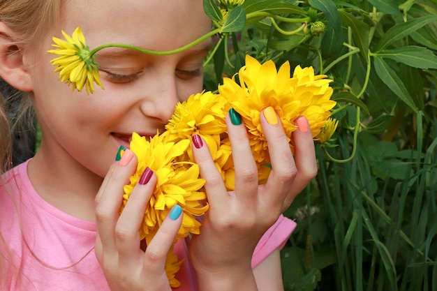 Los niños son manicura multicolor en un niño con flores.