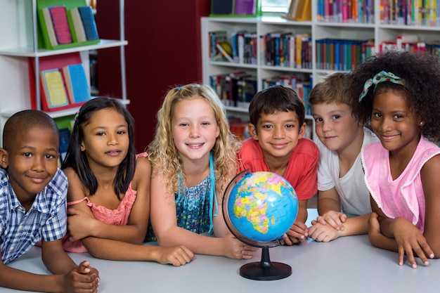 Niños sonrientes con globo en la mesa