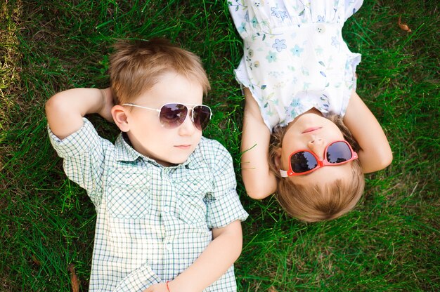 Niños sonrientes en el jardín con gafas de sol.