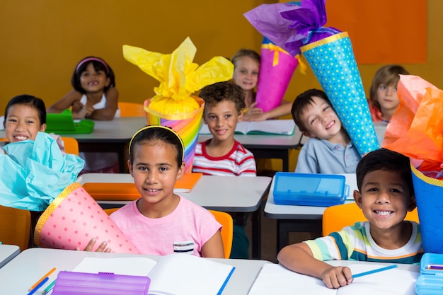 Foto niños sonrientes con trabajo artesanal sentado en el banco