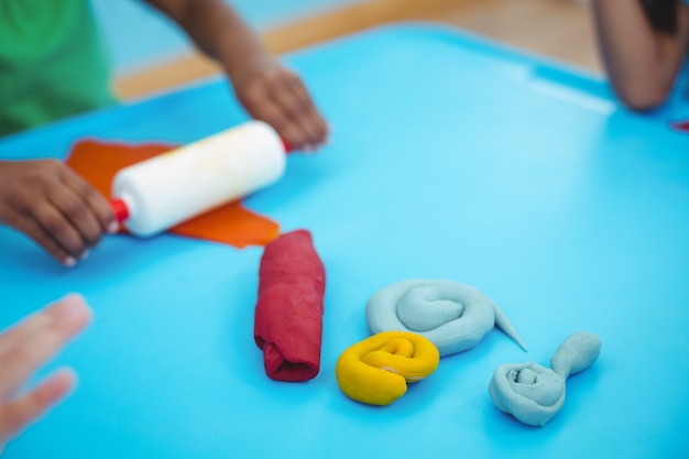 Niños sonrientes usando plastilina