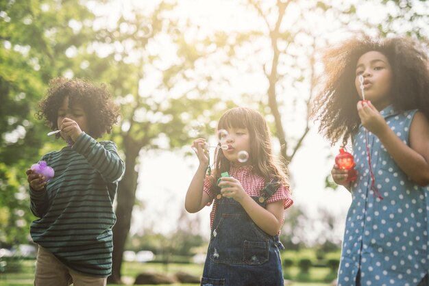 Foto niños soplando burbujas en el parque