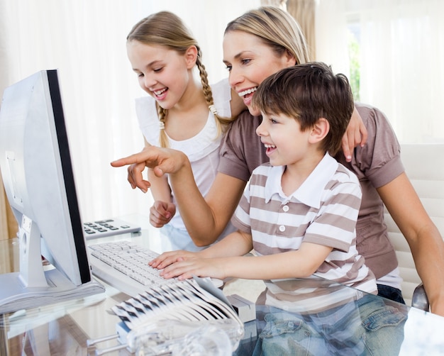 Los niños y su madre usando una computadora