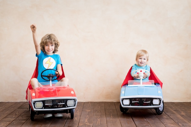 Foto niños superhéroes jugando en casa.