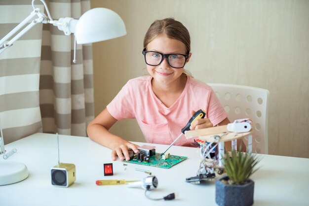 Foto niños tecnología y concepto de ciencia niña feliz jugando con kit de robótica en casa distanciamiento social aislamiento