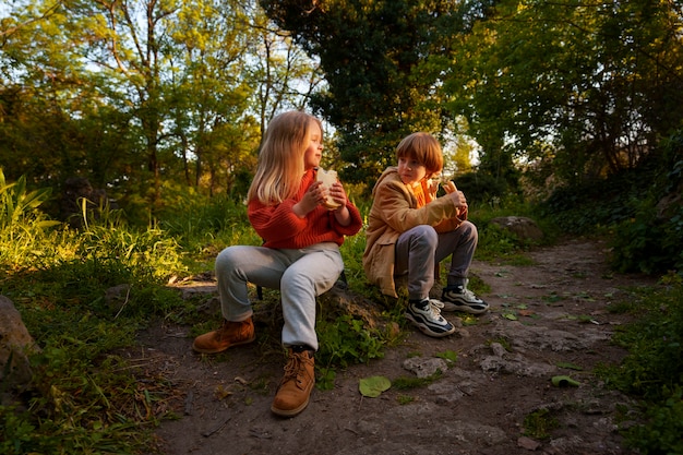 Niños de tiro completo explorando la naturaleza juntos