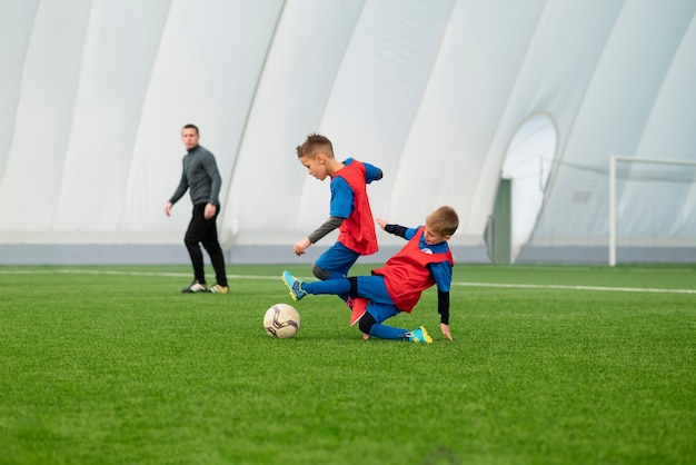 Niños de tiro completo jugando al fútbol