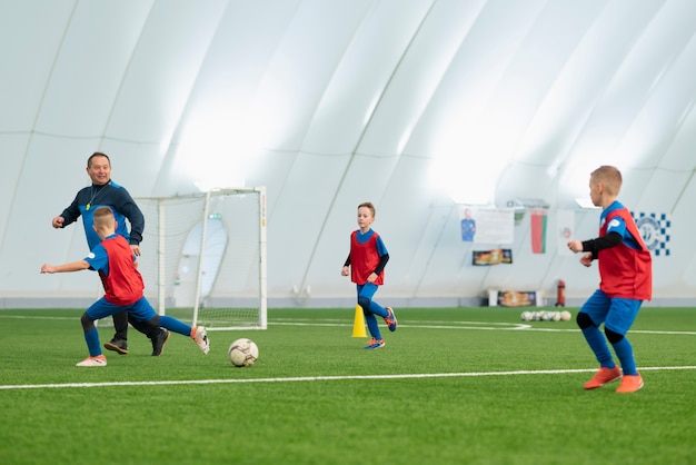 Foto niños de tiro completo jugando al fútbol