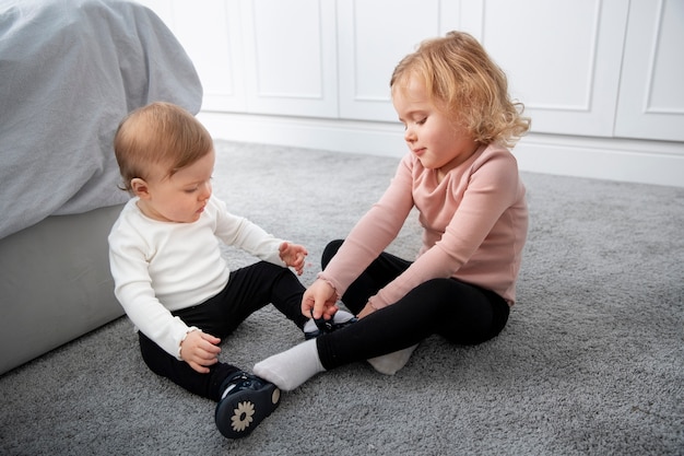 Niños de tiro completo jugando en el piso