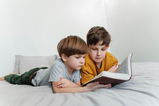 Niños de tiro completo leyendo la biblia juntos