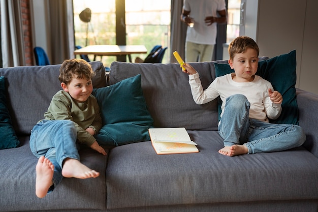 Foto niños de tiro completo sentados en el sofá