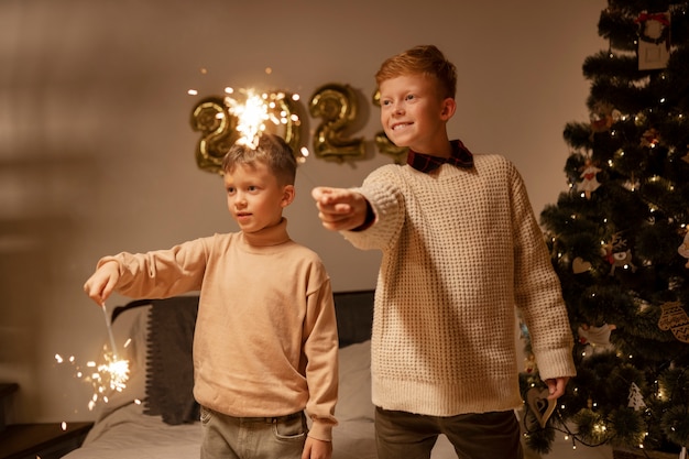 Foto niños de tiro medio con fuegos artificiales