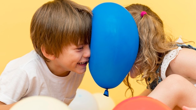 Foto niños de tiro medio jugando con globo