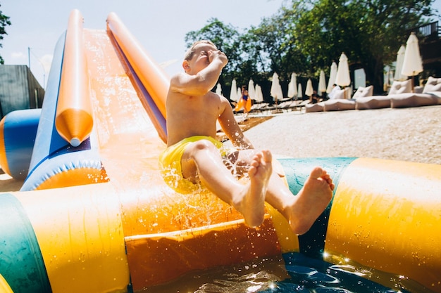 Niños en tobogán de agua en parque acuáticoxA