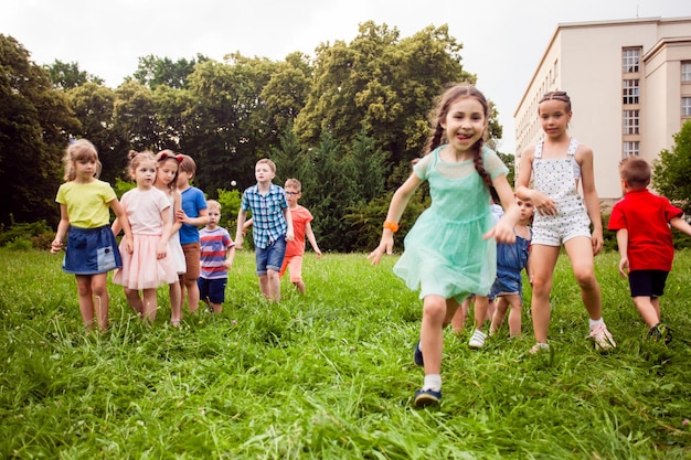 Los niños de todas las edades juegan con entusiasmo a la carrera en el parque.