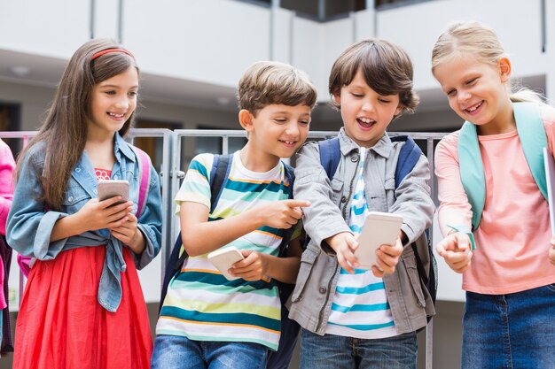 Niños tomando selfie con teléfono móvil