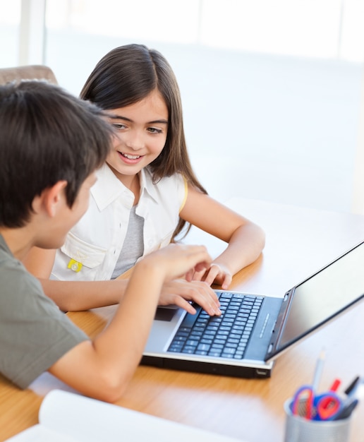 Niños trabajando en su computadora portátil en casa