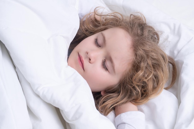Niños tranquilos duermen niño pequeño durmiendo en la cama niño lindo durmiendo bien solo en la cama bajo la manta niño