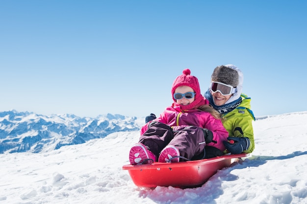 Niños en trineo sobre nieve