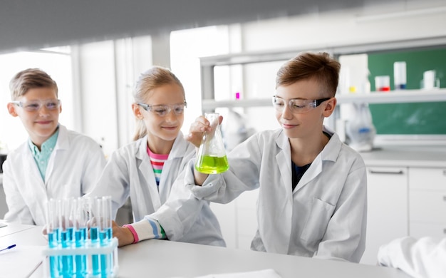 Foto niños con tubos de ensayo estudiando química en la escuela