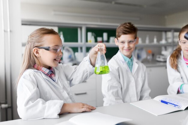 niños con tubos de ensayo estudiando química en la escuela