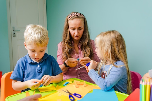 Los niños y el tutor estudian juntos en la escuela creativa.