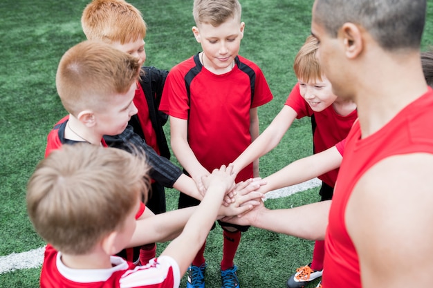 Niños uniendo sus manos antes del partido