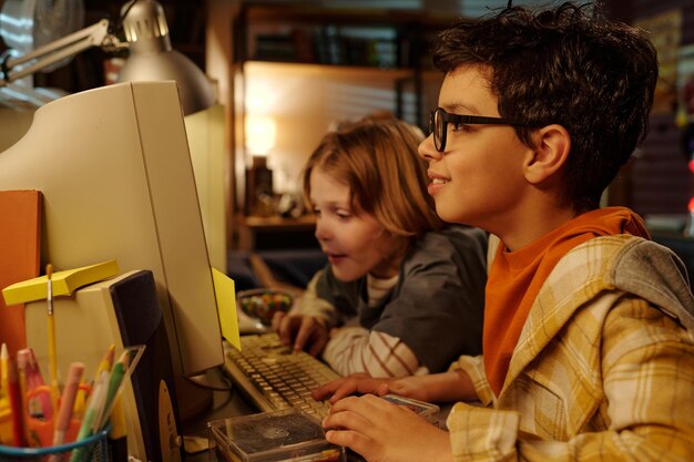 Los niños usan la computadora en un ambiente acogedor en el hogar