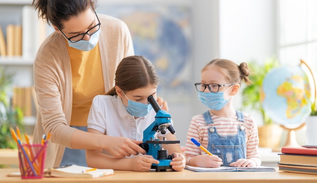 Los niños usan mascarillas aprendiendo en clase