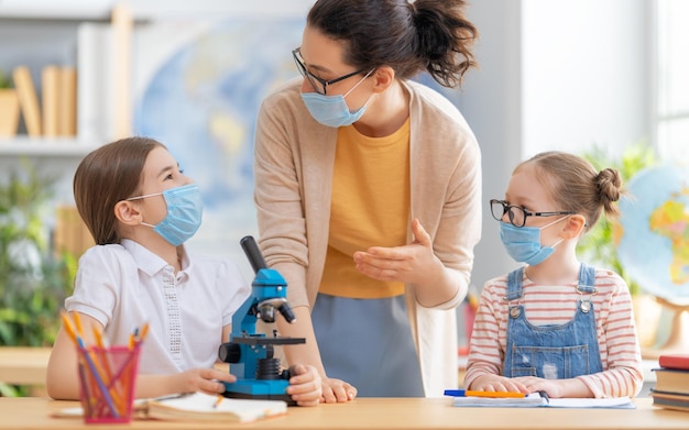 Los niños usan mascarillas aprendiendo en clase