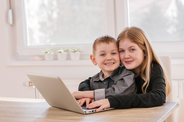 Niños usando laptop en casa