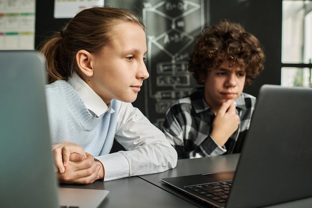 Niños usando laptop en clase